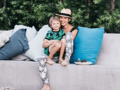 Lena Headey is sitting on a couch while keeping Wylie Elliot Loughran in her lap.